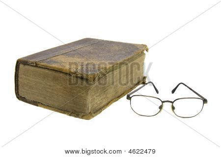 Gafas de cerca muy antigua Biblia sobre fondo blanco