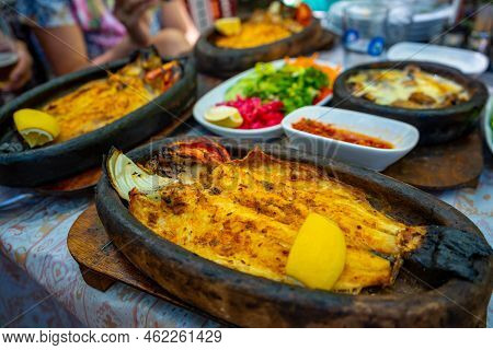 Fish Dish In Tropic Restaurants On The River. Places On The River With Tourists In Forest, Turkey