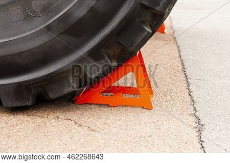 Red Block, Chock, Under The Wheel Of A Mining Truck. Brake Shoe, Emphasis. Safety Engineering.