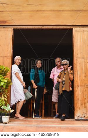 Happy Serion People With Adult Daughter Standing In The Door Frame Or The House