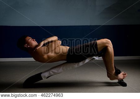 Shirtless 19 Year Old Teenage Boy Soing Situps On An Exercise Bench