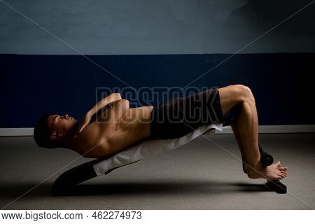 Shirtless 19 Year Old Teenage Boy Soing Situps On An Exercise Bench