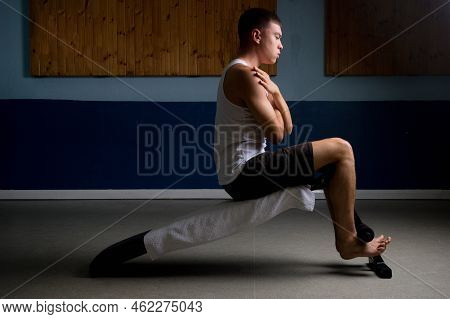 19 Year Old Teenage Boy Doing Situps On An Excercise Bench In A Tank Top
