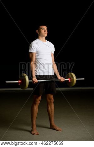 19 Year Old Teenage Boy Excercising His Biceps With A Barbell