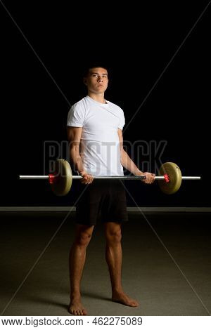 19 Year Old Teenage Boy Excercising His Biceps With A Barbell