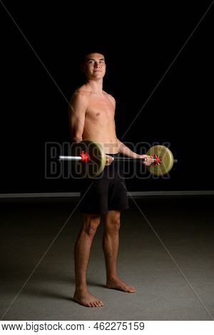 Shirtless 19 Year Old Teenage Boy Excercsing His Bicpes With A Barbell