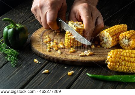 The Chef Cuts Corn With A Knife. Maize Is An Excellent Dietary Breakfast Or Lunch Prepared By The Co