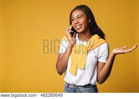 Satisfied Carefree African-american Woman With Dreadlocks, Talks Via Smartphone, Has Pleasant Phone 