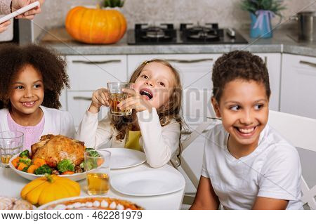 Happy Children At The Festive Table. Traditional Thanksgiving Dinner. We Instill Traditions In Child