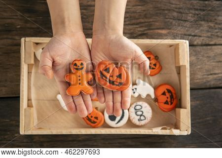 Gingerbread In Form Of Pumpkin And Gingerbread Man In Childrens Hands. Festive Cookies For Halloween