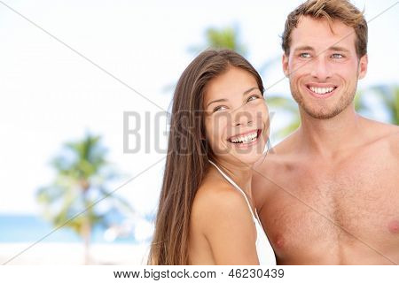 Coppia giovane romantiche sulla spiaggia vacanza sorridente felice al lato. Giovane coppia interrazziale sposi
