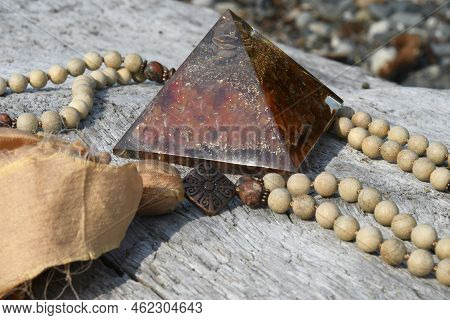 A Close Up Image Of A Handmade Mala Necklace With Carnelian Orgonite Pyramid.