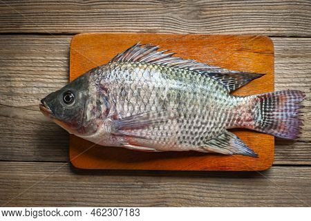 Tilapia On Wooden Cutting Board Background, Fresh Raw Tilapia Fish From The Tilapia Farm - Top View