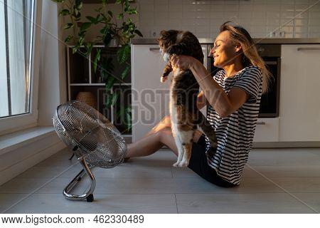 Domestic Cat Trying To Run Away From Blonde Owner Hates And Resists Cold Air Flow From Small Fan In 