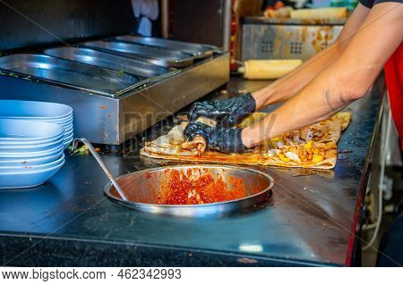 Turkish Street Food. Man Bakes Traditional Griddle-cake In Old Town Antalya, Turkey