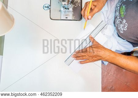Unrecognizable Latin Woman Measuring Pieces Of A Guayabera Shirt With A Ruler