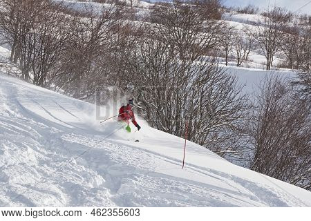 VALMOREL, FRANCE -CIRCA 2019: Skier coming down fast in fresh powder snow off-piste free ride. Plowing snow