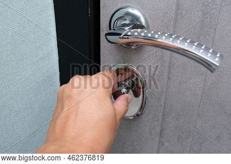 A Hand Locking The Door With A Door Knob For Security, Protection From Robbery And Theift