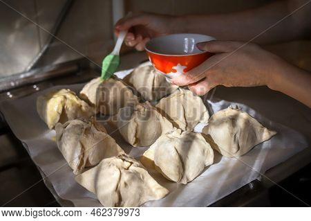 Making Apples Baked In Dough. Closeup Of Woman's Hands Spreading Egg Yolk With Silicone Culinary Bru