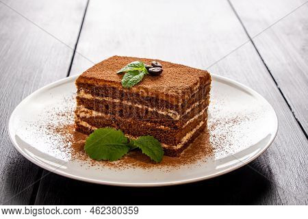 Tiramisu Dessert Decorated With Mint On White Plate. Slice Of Coffee Cake On Light Background. Tradi
