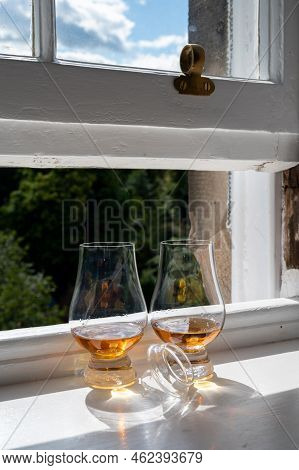Two Glasses Of Single Malt Scotch Whisky Served On Old Window Sill In Scottisch House With View On O