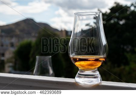 Glass Of Single Malt Scotch Whisky Served On Old Window Sill In Scottisch House With View On Old Par
