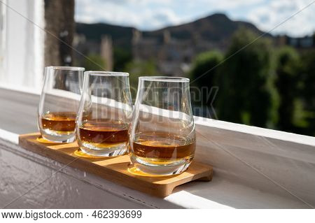 Flight Of Single Malt Scotch Whisky Served On Old Window Sill In Scottisch House With View On Old Pa