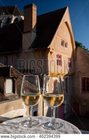Tasting Of White Grand Cru Classe Chablis Wine With Old French Houses On Background, Burgundy, Franc