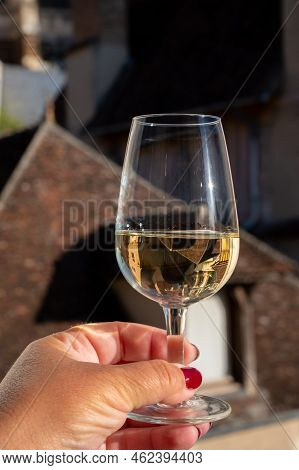 Tasting Of White Grand Cru Classe Chablis Wine With Old French Houses On Background, Burgundy, Franc