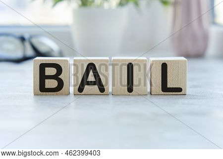 Word Bail On Wooden Cubes On Blue Background. The Inscription On The Cubes Is Reflected From The Sur