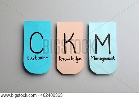 Notes With Abbreviation Ckm (customer Knowledge Management) On Light Background, Flat Lay