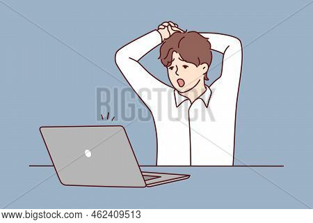Tired Man Sit At Table Work On Computer Yawning. Exhausted Male Overwhelmed With Laptop Job In Offic