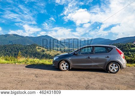 Mizhhirya, Ukraine September 20, 2021. Car On The Background Of Forested Mountains, Blue Sky With Cl