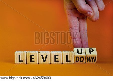 Level Up Or Down Symbol. Businessman Turns Cubes And Changes Concept Words Level Down To Level Up. B