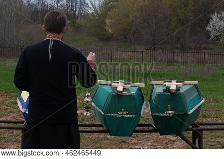 Bucha, Ukraine, 04-10-2022: Father Blesses The Coffins Of The Reservist Soldiers Who Died During The