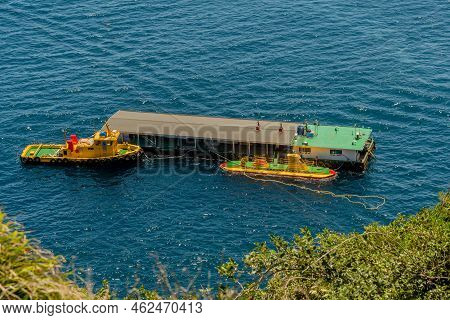 Udo, South Korea; June 22, 2022: Tourist Submarine And Tug Boat Moored To Floating Dock.