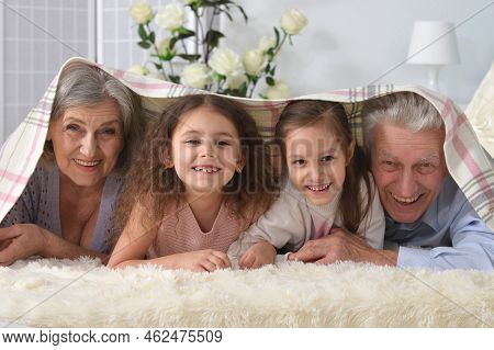 Grandparents And Grandchildren Lie On The Bed
