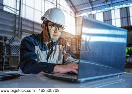 Asian Professional Heavy Industry Engineer Worker Wearing Safety Uniform And Hard Hat Uses Computer 