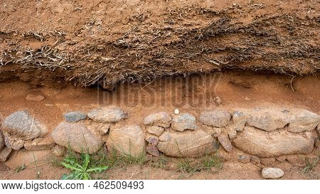 Close-up Background Of The Wall Of An Old House Made Of Clay Mixed With Straw. Old Type Of Construct