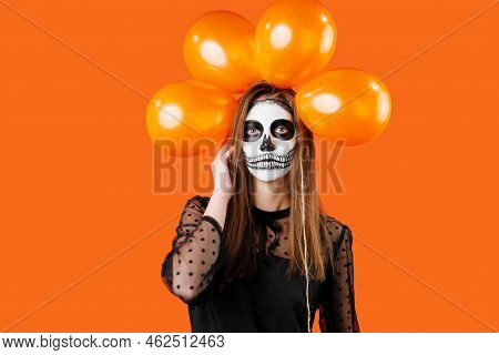 Portrait Of Young Brown Girl With Cadavre Makeup Mask And Balloons Above The Head.