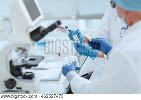 Pharmacists Discussing A New Drug In The Laboratory .