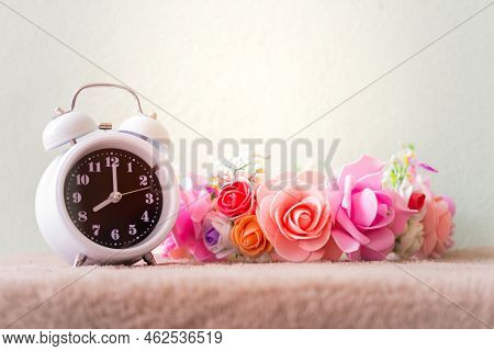 White Clock With Flowers On A Table In Muted Vintage Retro Style.
