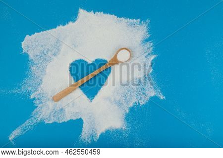 Collagen Powder Or Protein Is Chaotically Scattered On Blue Surface. Empty Space In The Form Of Hear
