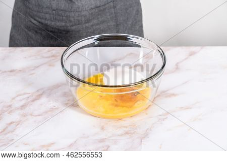Mixing Ingredients In A Large Glass Mixing Bowl To Bake Apple Sharlotka Muffin.