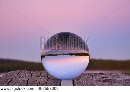 Glass Ball On A Wooden Pier At A Swedish Lake At Evening Hour. Nature Shot From Scandinavia