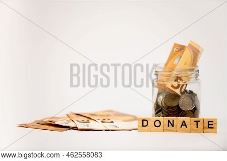 Donation Concept. Donation Jar With Coins, Euro And Wooden Letters