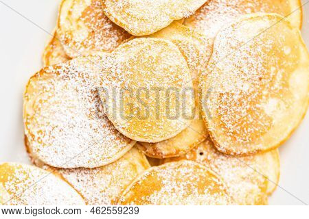 Flat Lay. Freshly Made Small Pancakes On A Kefir Base Garnished With Powdered Sugar.