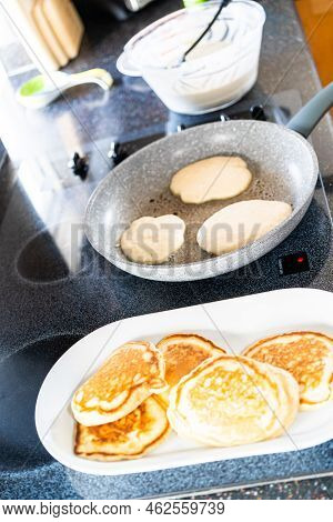 Frying Kefir Based Pancakes In Cooking Pan On An Electric Stove.