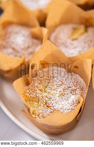 Garnishing Freshly Baked Apple Sharlotka Muffins Dusted With Powdered Sugar.