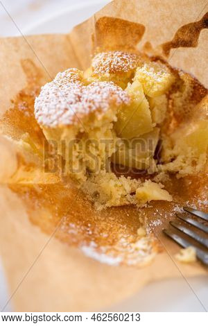 Eating Freshly Baked Apple Sharlotka Muffin Dusted With Powdered Sugar.